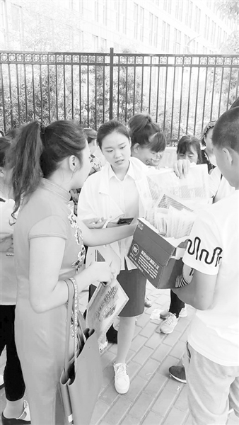 志愿者到各中考考点免费为考生发放矿泉水和考